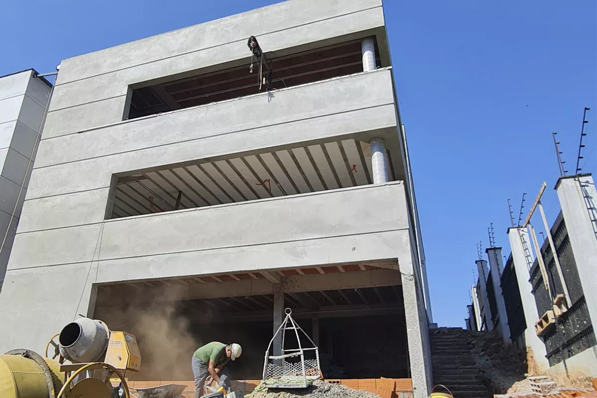 Obras casa Hexus - Estrutura de prédio comercial em construção, pavimentos elevados com vigas e pilares aparentes, demonstrando objetividade e foco em resultados mensuráveis.