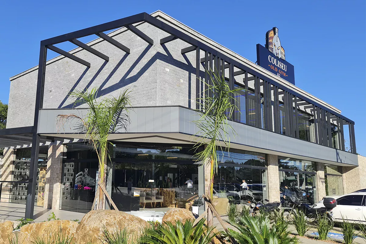 Obras casa Me - Fachada residencial térrea, telhado aparente, detalhes em pedra e madeira, jardim florido e acessibilidade, destacando alto padrão de acabamento e inovação em soluções residenciais.