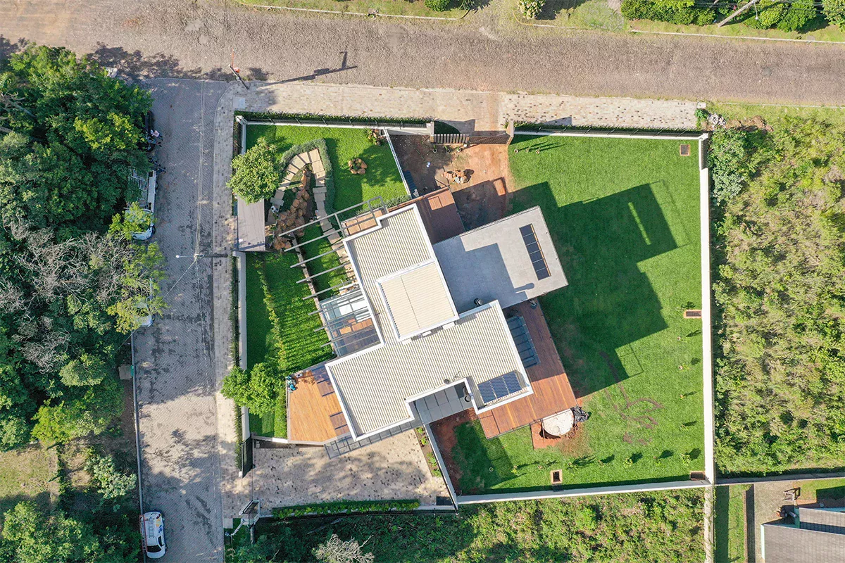 Obras casa MR - Visão aérea de projeto residencial com piscina, áreas verdes e arquitetura sofisticada, representando foco em performance, gestão comercial eficiente e ambientes funcionais.