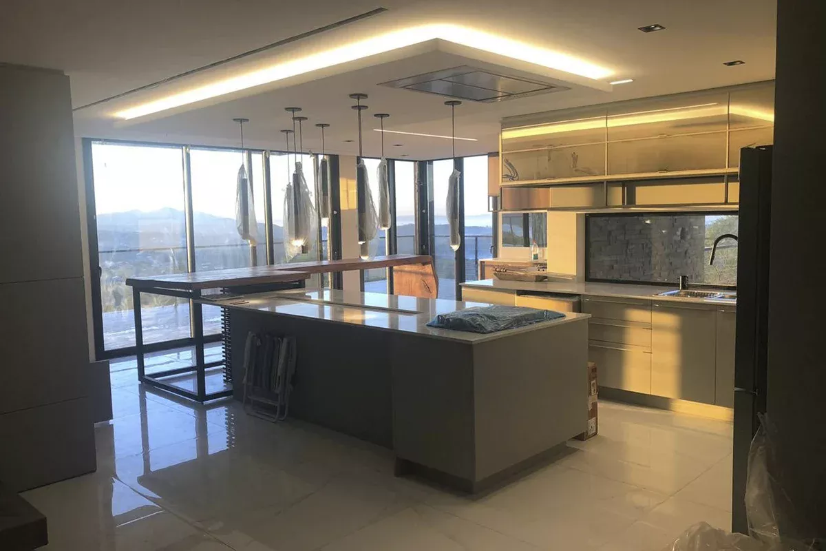 Obras casa MR - Cozinha gourmet integrada à sala de jantar, móveis planejados, ilha central e iluminação embutida, destacando funcionalidade, Soluções em Comunicação inovadoras e excelência em ambientes residenciais.
