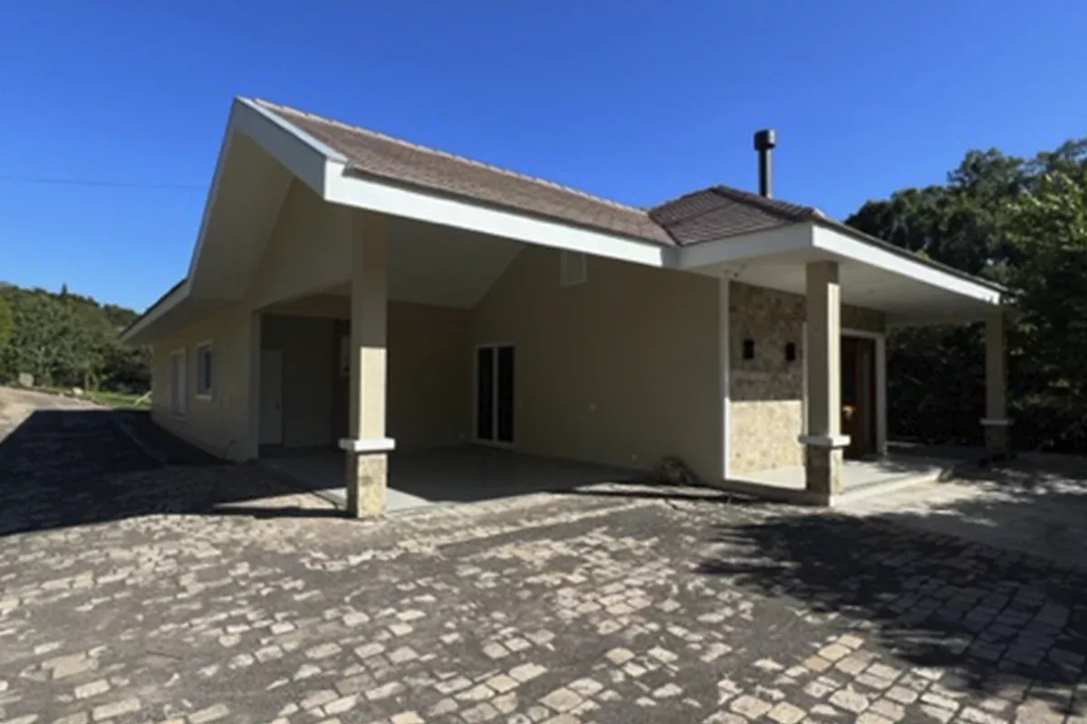 Obras casa J+S - Fachada de casa térrea com piso em pedra e garagem coberta, mostrando funcionalidade, acessibilidade e alto padrão construtivo.